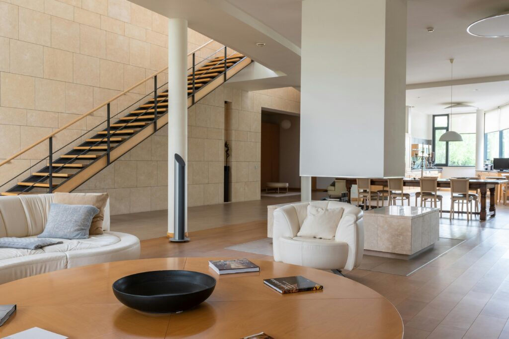 pexels-photo-6908365-6908365 A luxurious and spacious modern living room featuring an open staircase and elegant furnishings.